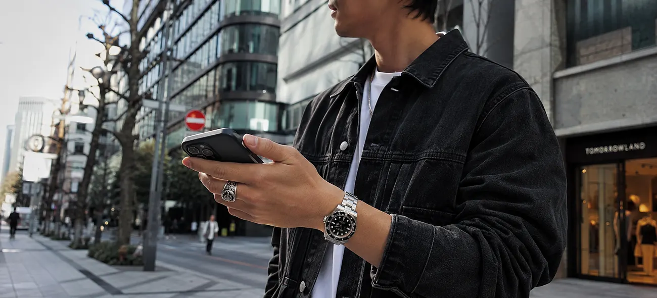 街中でロレックスの時計を着用しているスタイリッシュな男性